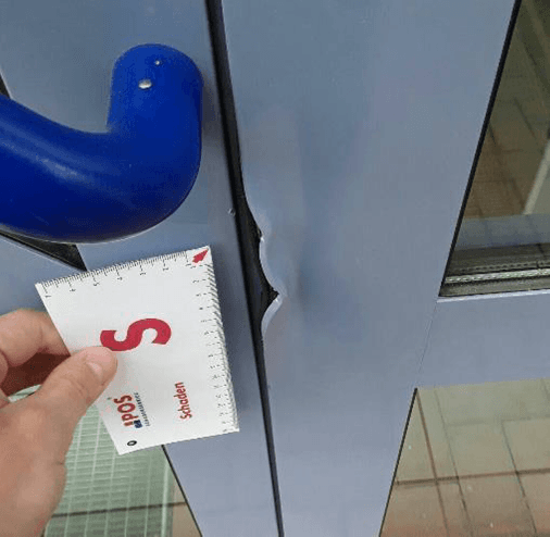 A hand holding a card next to a blue handle.